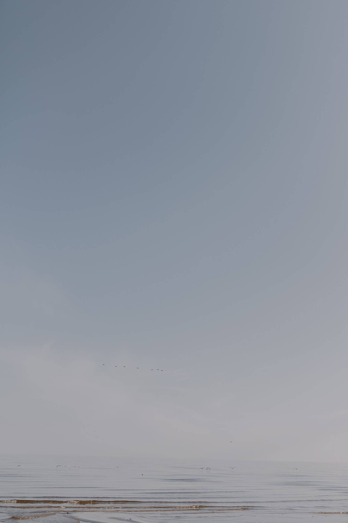 El mar y el cielo se encuentran en un horizonte azul.